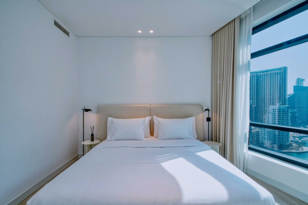 Elegant bedroom in a furnished rental with stunning cityscape view.